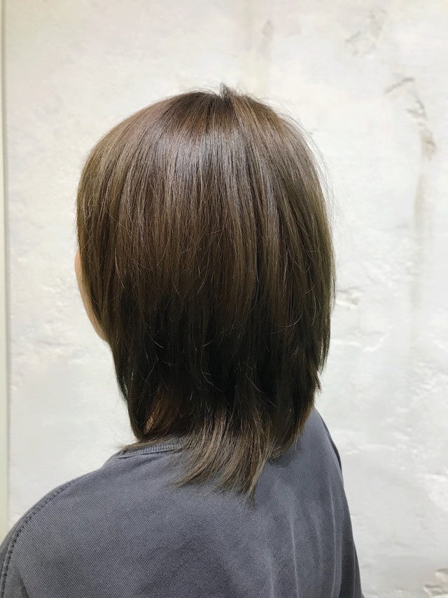 アッシュグリーンカラーのストレートヘアの女性の後ろ姿