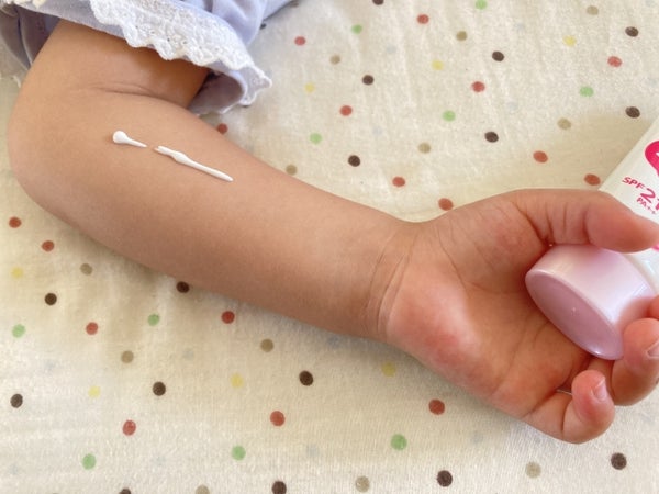 日焼止めをのせた子どもの腕