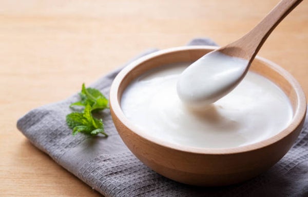 木の器に盛られたヨーグルトを木のスプーンですくう様子