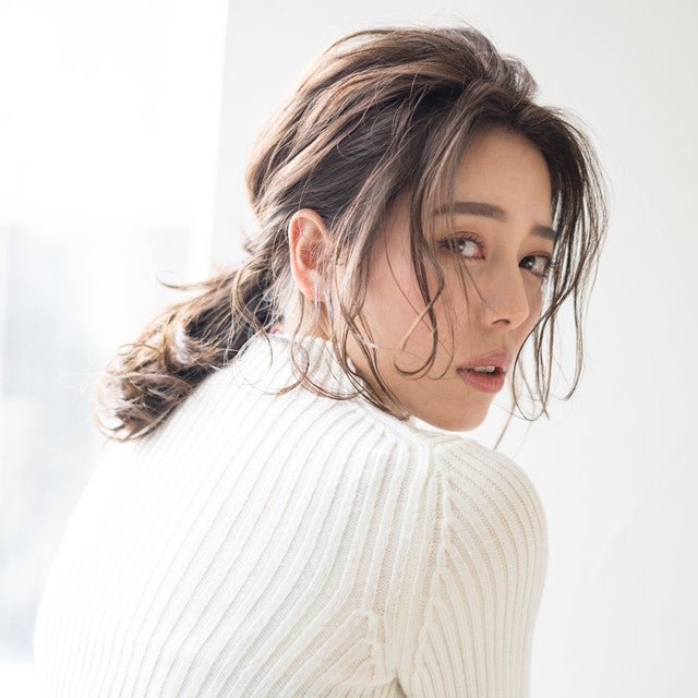 前髪を分けたポニーテールの女性