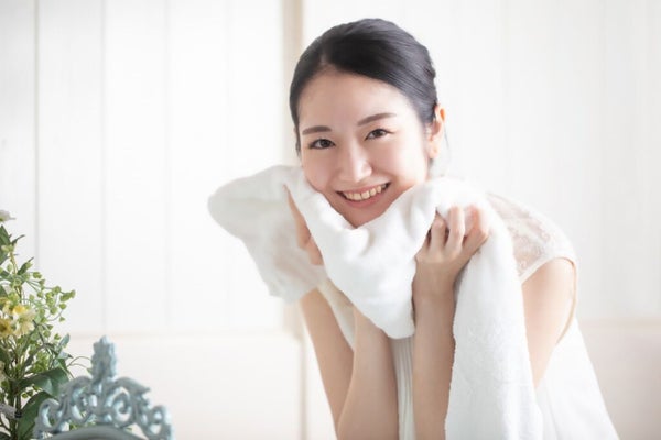 タオルで顔を拭く女性