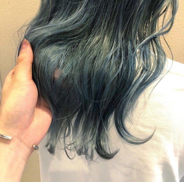 アッシュグリーンカラーのセミロングスタイルの女性