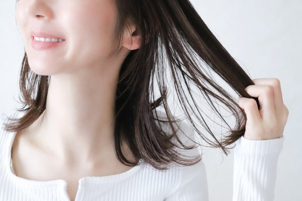 髪の毛をさわる女性