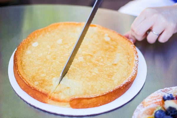 白いお皿に乗ったケーキをナイフで切る様子