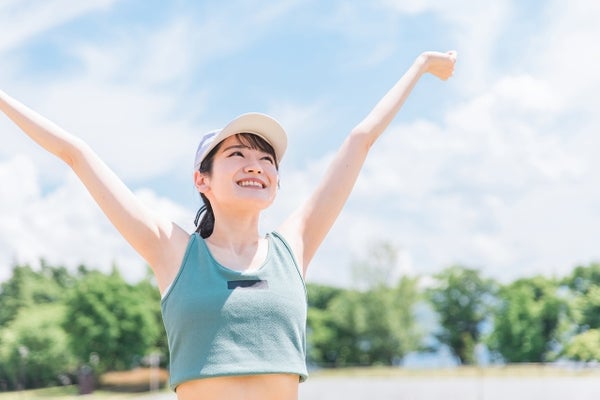 外で伸びをしている女性