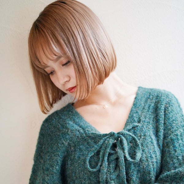 明るいベージュカラーの髪色のボブヘアの女性