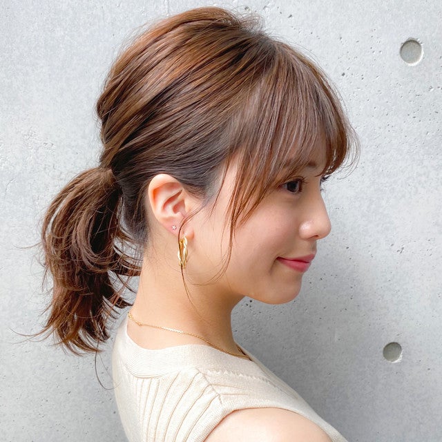 薄め後れ毛でオフィスにもぴったりなすっきりポニーテール姿の女性