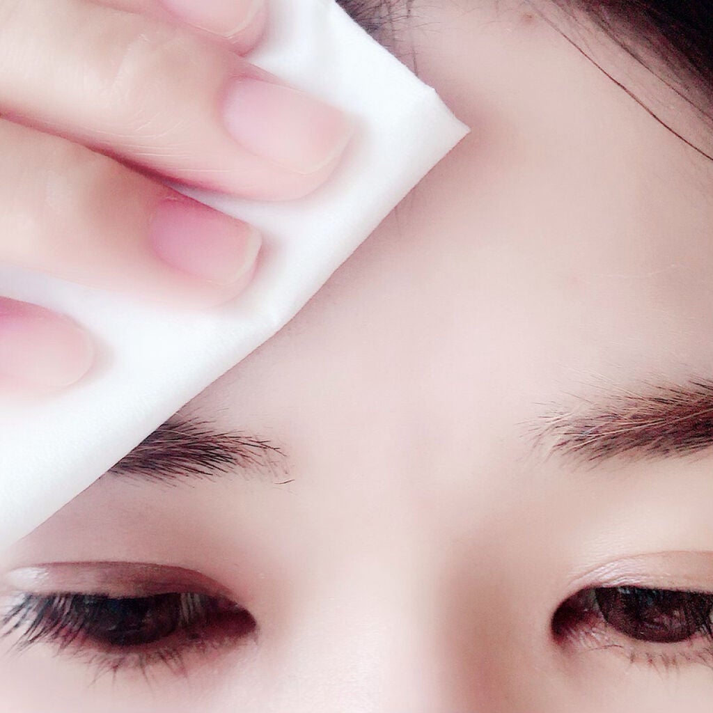 顔にティッシュを当てる女性