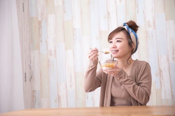 オートミールとヨーグルトを食べている女性