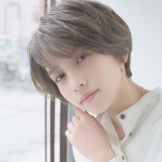 明るいアッシュグリーンカラーのショートヘアの女性