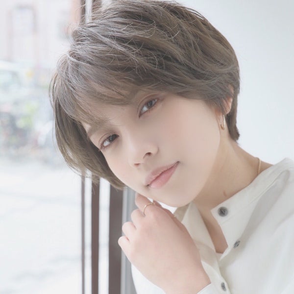 明るいアッシュグリーンカラーのショートヘアの女性