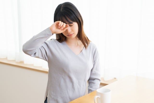目をこすっている女性