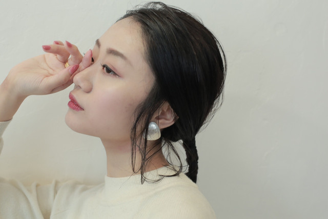 目元に手を当てたセンター分け前髪の女性