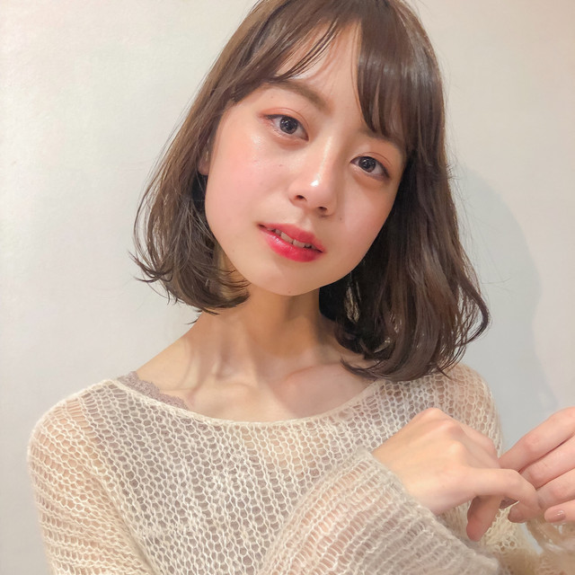 前髪を流したタンバルモリヘアの女性