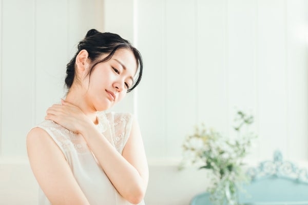 肩を押さえている女性
