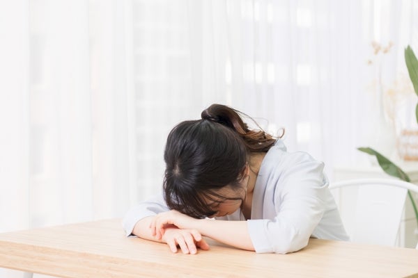 机に突っ伏している女性