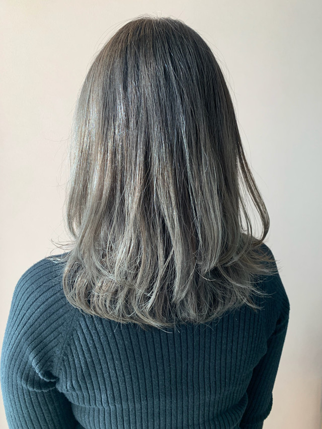 明るめアッシュグレーのミディアムヘアをした女性の後ろ姿