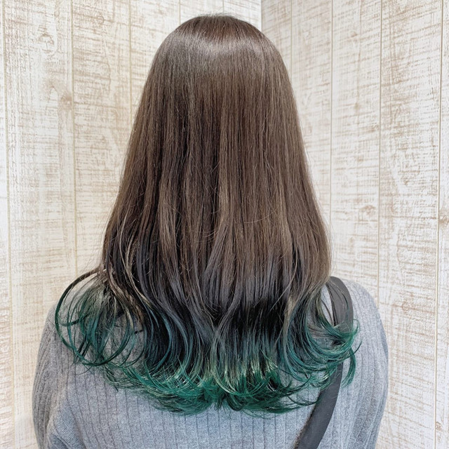 裾カラーにアッシュグリーンを取り入れたロングヘアの女性の後ろ姿