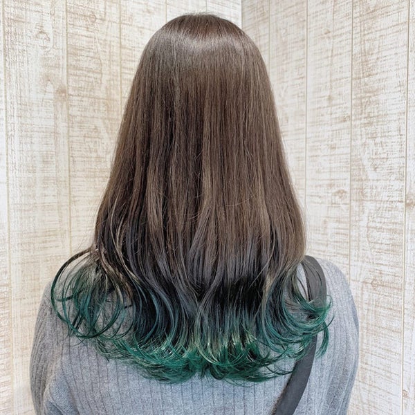 裾カラーにアッシュグリーンを取り入れたロングヘアの女性の後ろ姿