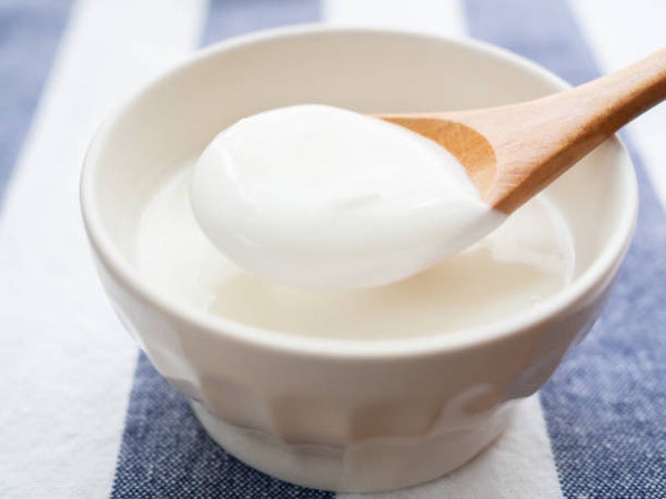 器に盛られたヨーグルトを木のスプーンですくう様子