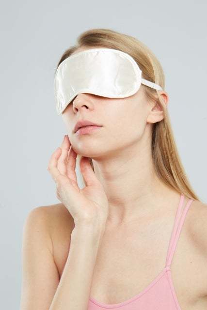 顎に手を添えるアイマスクをした女性