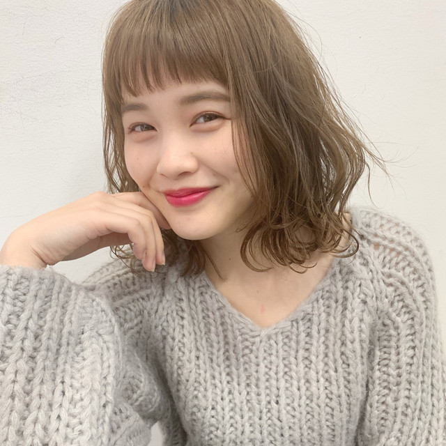 アッシュグリーンカラーのエアリーな切りっぱなしボブスタイルの女性