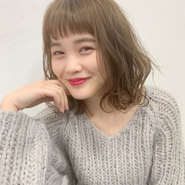 アッシュグリーンカラーのエアリーな切りっぱなしボブスタイルの女性