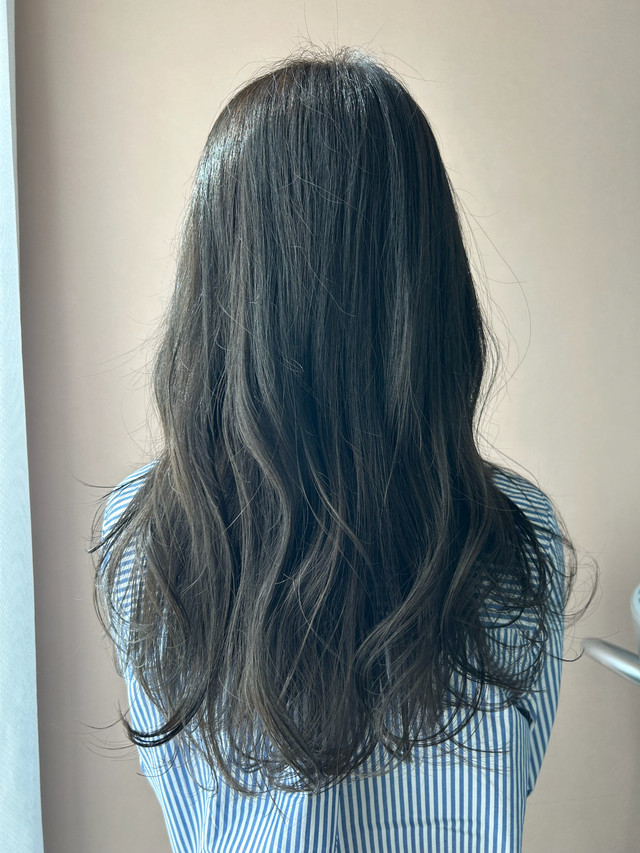 暗いオリーブカラーの髪色のロングヘアの女性