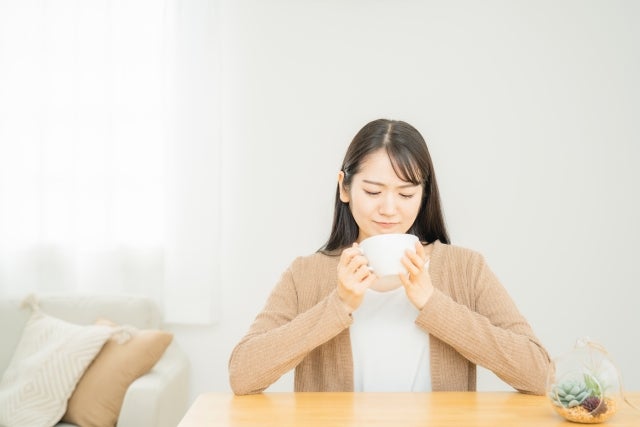美味しくなさそうに食事をする女性