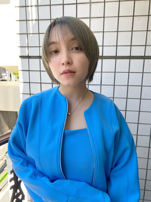 水色の服を着たショートカットの女性