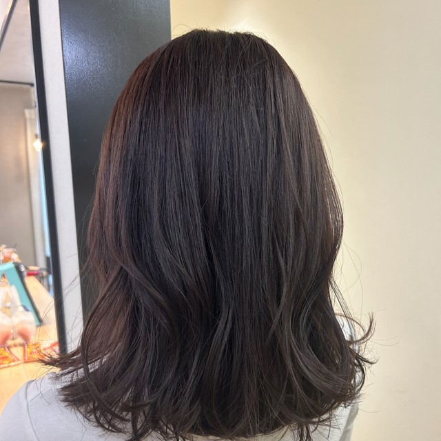 ピンクラベンダーの髪色が似合う女性の後ろ姿。