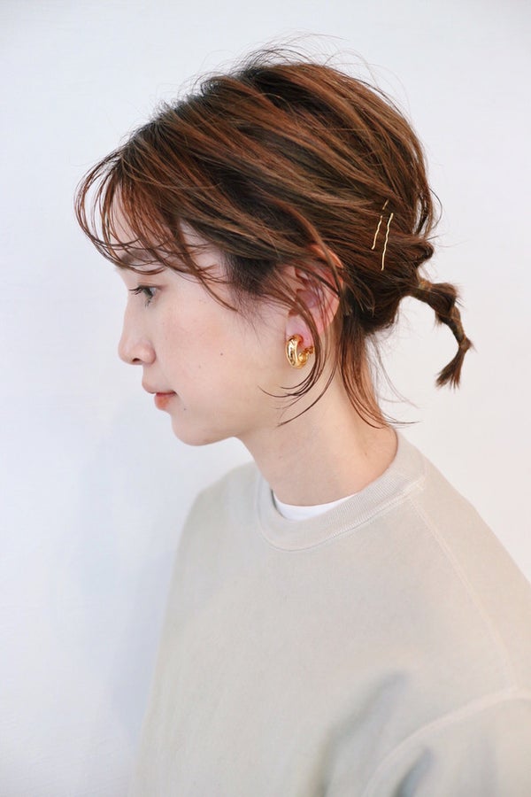 ポニーテールの毛束を2ヶ所結んだ女性の横顔