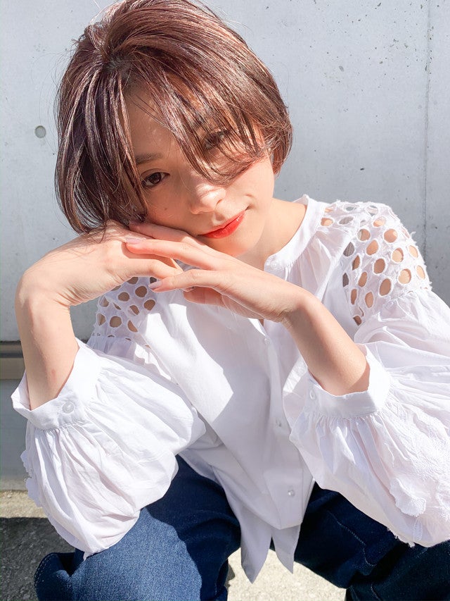 顔の半分が隠れるくらい前髪が長いボブヘアの女性