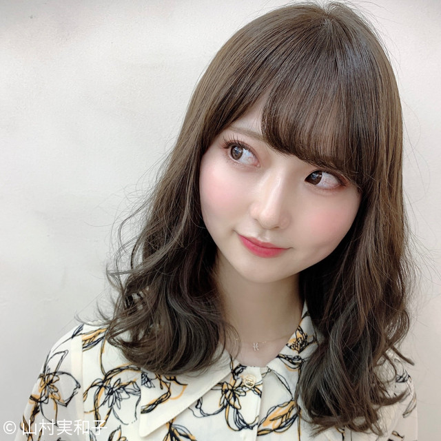 丸顔で眉毛がふんわりとした印象の女性。