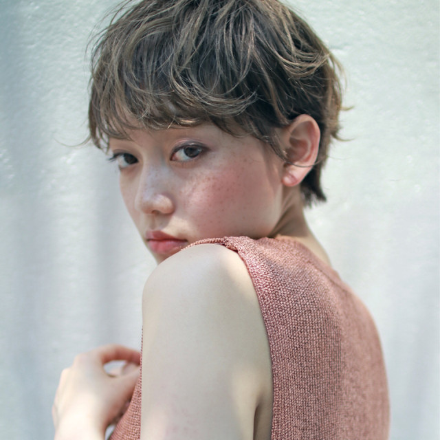 明るいアッシュグリーンカラーのショートヘアの女性