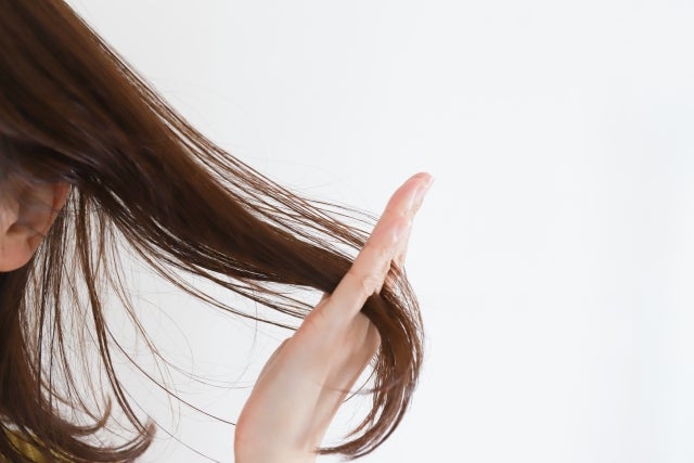 手で髪をとかす女性