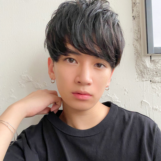 暗髪のマッシュヘアが似合う男性。