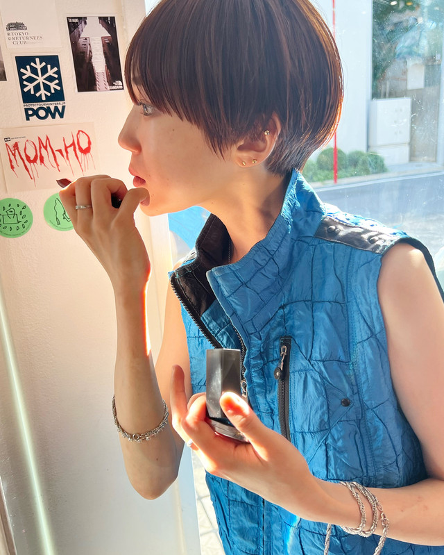 鏡を見ながらリップを塗っている女性